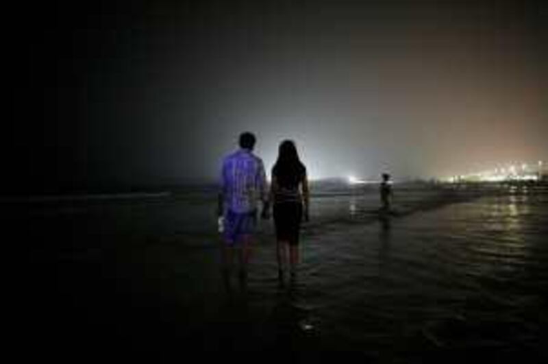 Dubai - July 8, 2008.  A couple walk on the public beach at night, near the Jumeirah Beach Hotel. ( Philip Cheung / The National ) EDITORS NOTE: POSSIBLE OASIS *** Local Caption ***  PC0135-dubai2.jpgPC0135-dubai2.jpg