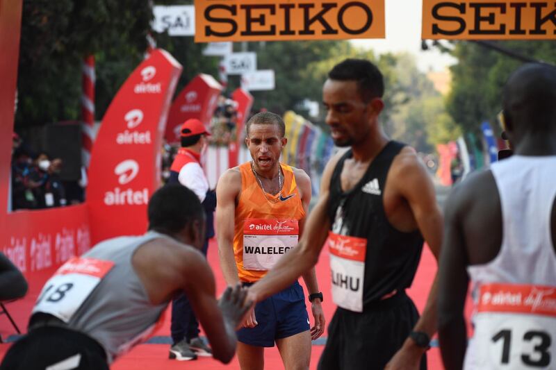 Ethiopian athlete Amedework Walelegn, centre, after the marathon in New Delhi. AFP