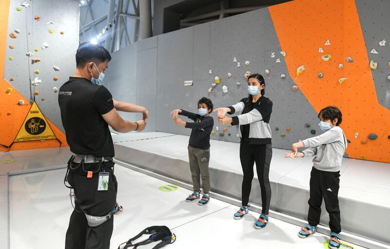 Abu Dhabi, United Arab Emirates - Mazen, 7, and Samih, 9, along with their mother Samia, stretch before taking on indoor climbing at CLYMB, Yas Island. Khushnum Bhandari for The National