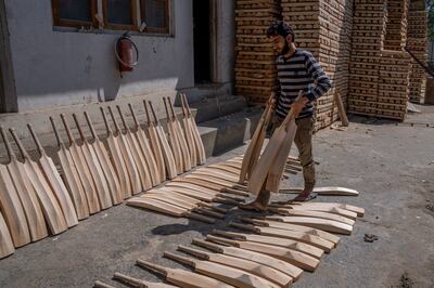 Imran Malik carries unfinished cricket bats made from willow at a factory in Awantipora, south of Srinagar. AP Photo