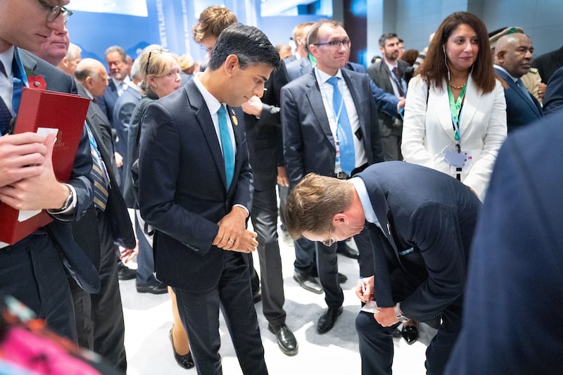 Prime Minister of Sweden Ulf Kristersson writes down his contact details for Mr Sunak during the Cop27 climate conference. Getty