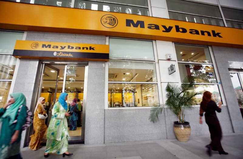 FILE PHOTO: Customers leave a branch of Malaysia's Maybank in Putrajaya October 9, 2009. REUTERS/Bazuki Muhammad/File Photo