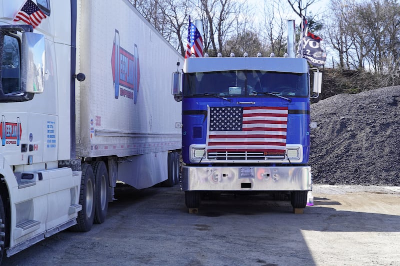 An American flag covers the grill of a lorry at the rally.