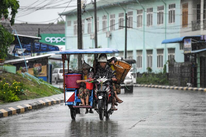 People ride an autorickshaw amid heavy rains in Kyauktaw. AFP