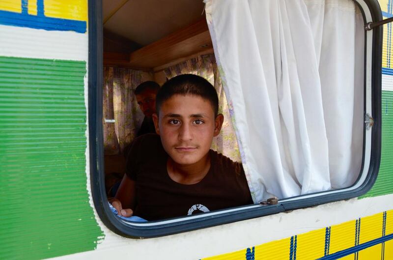 Afghan refugee Safi, 14, looks out of the window of a caravan he is sleeping in with five other Afghan refugees in Calais' so-called 'Jungle' camp. Kate Shuttleworth for The National