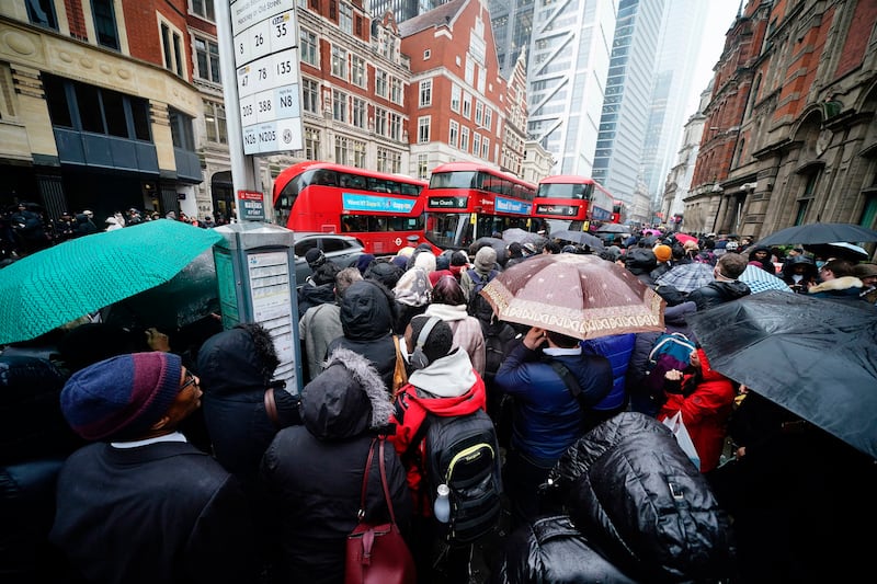People wait to get on a bus at Liverpool Street station in London on Tuesday morning, during a strike by members of the Rail, Maritime and Transport union. All London Underground lines were suspended for the day. PA
