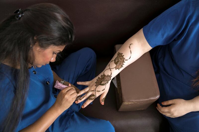 ABU DHABI, UNITED ARAB EMIRATES - AUGUST 16, 2018. 

Chathurika Samanmali, 25, puts henna on Mafia Shabbir, 28, her colleague, at Abeer Beauty & Henna salon in Baniyas.

(Photo by Reem Mohammed/The National)

Reporter: Anna Zacharias
Section:  NA