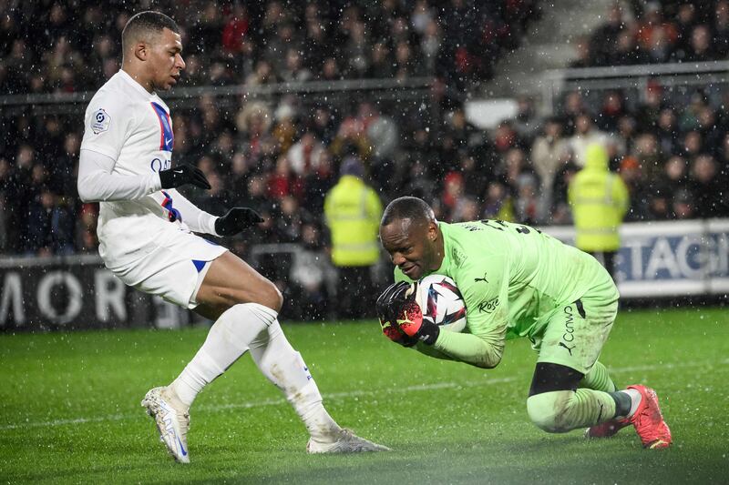 Rennes goalkeeper Steve Mandanda catches the ball in front of Paris Saint-Germain's Kylian Mbappe. AFP