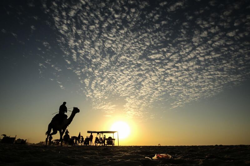 A Palestinian man rides a camel at a beach in Gaza City.  AFP