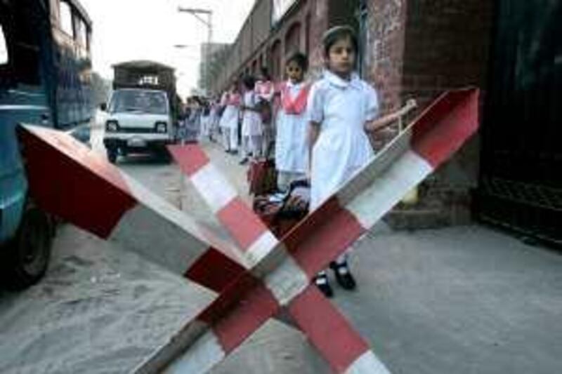 Pakistani students arrive at their school after its reopen, Monday, Oct. 26, 2009 in Lahore, Pakistan. Pakistani authorities reopened all educational institutions, which were closed after twin suicide bombings at  International Islamic University in Islamabad last week. (AP Photo/K.M.Chaudary) *** Local Caption ***  LHR105_Pakistan.jpg *** Local Caption ***  LHR105_Pakistan.jpg