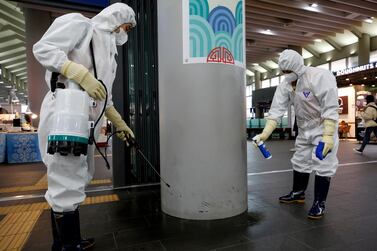 Sanitation workers spray disinfectant, as a precaution against coronavirus, at Suseo Station in Seoul. In China, 26 people have been killed by the virus. EPA