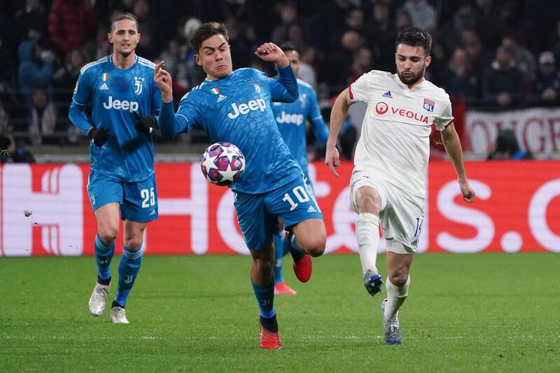 Juventus' Paulo Dybala, centre, and Lyon's Leo Dubois, right, vie for the ball at the Lyon Olympic Stadium. AP