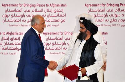 Zalmay Khalilzad and Taliban co-founder Abdul Ghani Baradar shake hands after signing the US withdrawal deal in Doha last year. AFP