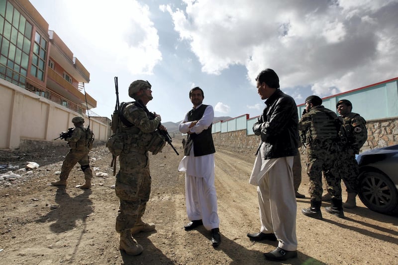 Afghan residents chat with U.S. Army Lieutenant Steven Gibbs of the PSD 3/1AD Special Troops Battalion as he patrols with his platoon in Pul-e Alam, a town in Logar province, eastern Afghanistan November 28, 2011. REUTERS/Umit Bektas (AFGHANISTAN - Tags: POLITICS MILITARY)