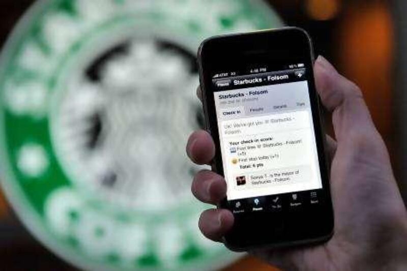 In this photo taken Friday Nov. 20, 2009, the Foursquare application is shown on an iPhone in front of a Starbucks in San Francisco. Foursquare lets you share your whereabouts with friends, no matter if you're at a hot new bar or a neighborhood pet store. (AP Photo/Russel A. Daniels)