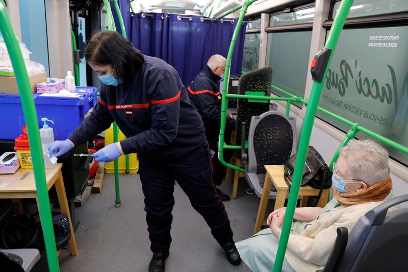 A firefighter prepares a dose of the Pfizer/BioNTech Covid-19 vaccine inside the Vacci'Bus, a bus converted into a vaccination center which travels through isolated villages near Reims, France. Reuters