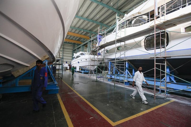 Workers in the production warehouse at the Gulf Craft factory in Umm Al Quwain. Sarah Dea / The National