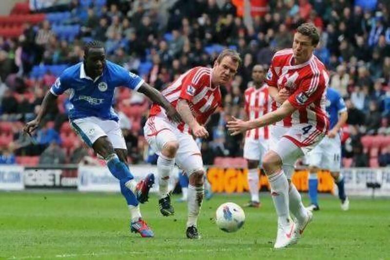 Victor Moses, left, who scored Wigan’s second goal, fires in a shot under pressure from Stoke’s Glenn Whelan.