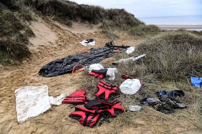 An inflatable boat, life vests and other material commonly used by migrants to cross the English Channel lies on a sand dune at Wimereux Beach, northern France. AFP