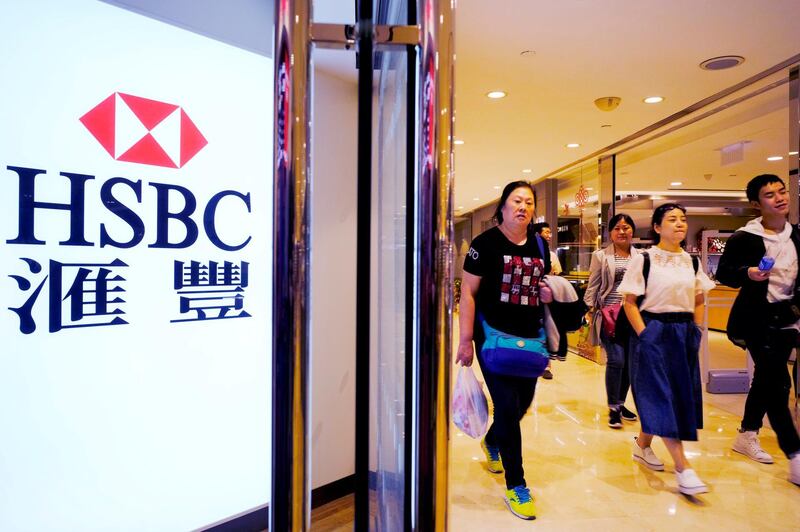 FILE - In this Feb. 20, 2018, file photo, people walk past an HSBC local branch in Hong Kong. Global bank HSBC says its pre-tax profit in the first half of the year rose 4.6 percent as its strategy focused on growing markets paid off. The London-based bank $10.7 billion pre-tax profit in January-June compared with $10.2 billion a year earlier. (AP Photo/Vincent Yu, File)