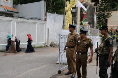In this Sunday, May 12, 2019, photo, Sri Lankan soldiers watch as a group of Muslim students walk past a closed catholic convent in Colombo, Sri Lanka. AP