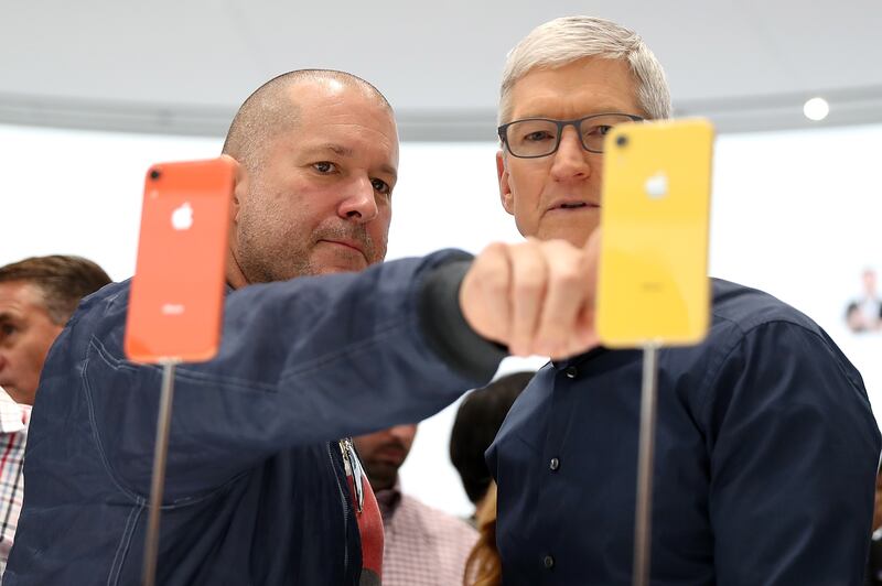 Former Apple chief design officer Jony Ive and Apple Chief Executive Tim Cook inspect the iPhone XR at an event in 2018 in Cupertino, California. Getty Images