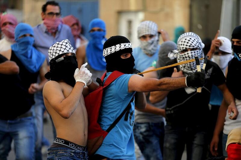 A Palestinian protester uses a slingshot to hurl a stone towards Israeli police during clashes in Shuafat, an Arab suburb of Jerusalem. Ammar Awad / Reuters