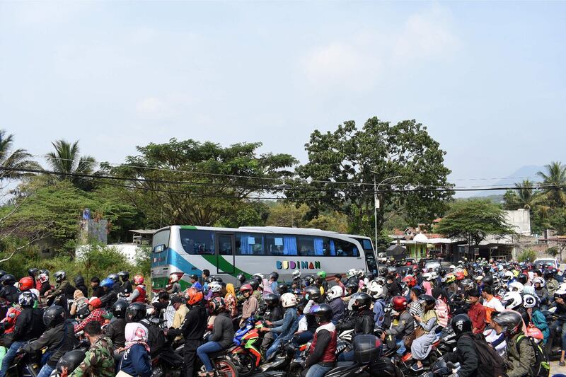 Indonesian motorists travel along a road in Garut, West Java as people return to their hometowns to celebrate Eid Al Fitr. AFP