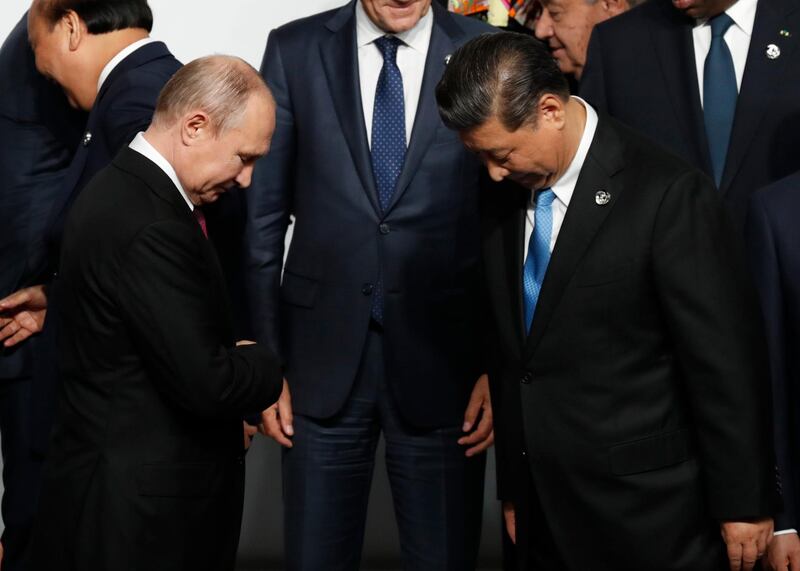 Mr Putin and Mr Xi prepare for a the G20's family photo. EPA