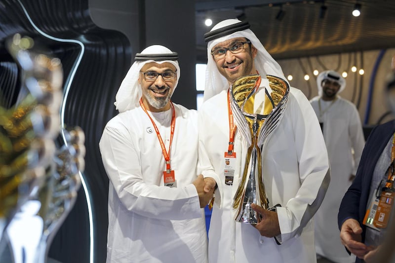 Sheikh Khalid bin Mohamed bin Zayed and Dr Sultan Al Jaber, Minister of State and chief executive of Adnoc, show off the new Formula One trophy