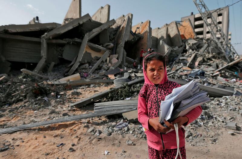 A Palestinian girl stands in front of the rubble of a building that was destroyed during Israeli airstrikes on Gaza City.   AFP