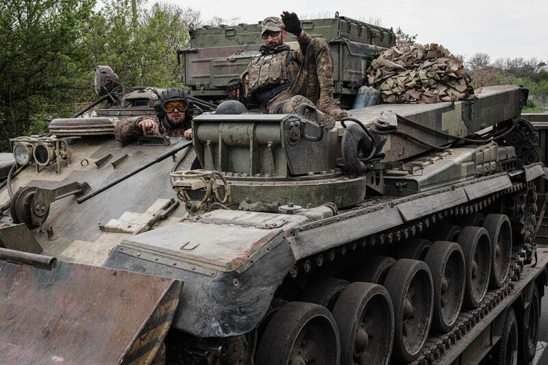 Ukrainian soldiers gestures on an armoured engineering vehicle carried on a tank transporter near Kramatorsk, eastern Ukraine, on April 30, 2022, amid the Russian invasion of Ukraine.  (Photo by Yasuyoshi CHIBA  /  AFP)