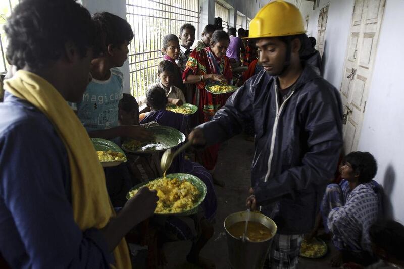 Evacuated Indian villagers eat food in a temporary cyclone shelter in Chatrapur. AP Photo/Biswaranjan Rout