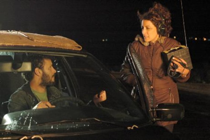 This undated photo released by Ustura Films shows Palestinian film director Najwa Najjar, right, with actor Ali Suleiman, on the movie set of "Pomegranates and Myrrh" in the West Bank town Ramallah. New Palestinian films tell stories through Palestinian eyes, trying to get beyond the simplicity of news coverage, which the artists say often reduces Palestinians to either militants or victims.(AP Photo/Ustara Films, Shuruq Harb) ** NO SALES **