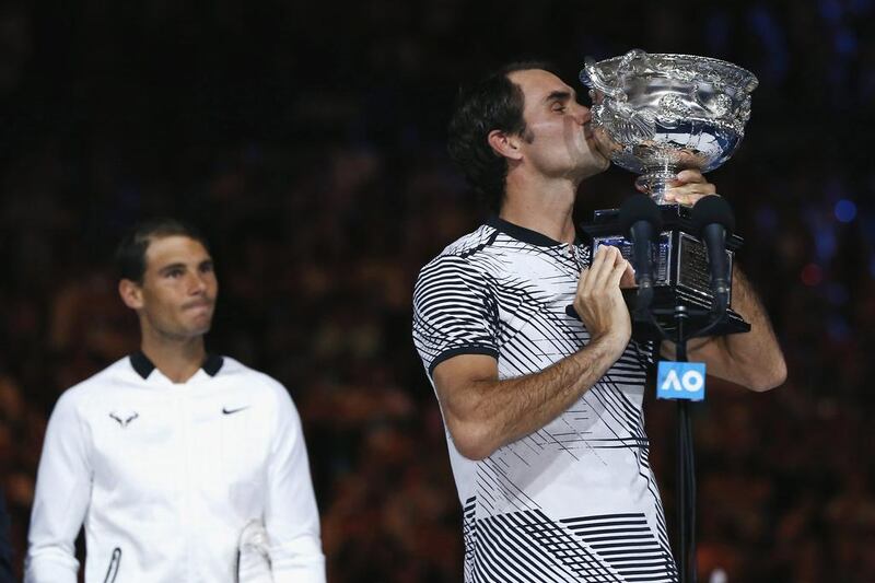 Roger Federer kisses the trophy after winning the Australian Open. Issei Kato / Reuters