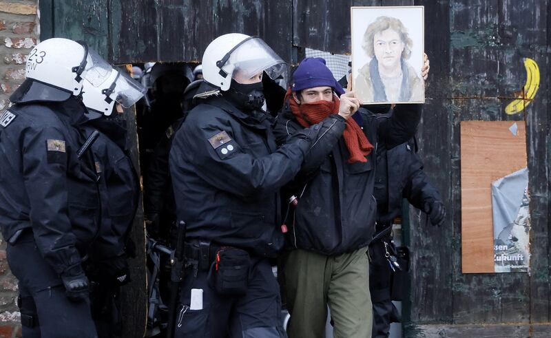 An activist shows a portrait of the farmer Eckardt Heukamp, who was the resident of Luetzerath to leave. EPA