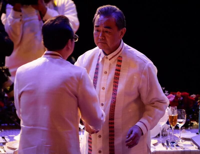 China's Foreign Minister Wang Yi (R) shakes hands with Philippine Foreign Secretary Alan Peter Cayetano (L) during the Gala Dinner of the Association of South East Asian Nations (ASEAN) Foreign Ministers Meeting (AMM) and Related Meetings in Manila, on August 6, 2017. 
Top diplomats from 27 countries gather in Manila for the 50th Association of South East Asian Nations (ASEAN) Foreign Ministers' Meeting (AMM) and Related Meetings from 2 to 8 August with the theme 'Partnering for Change, Engaging the World', to promote unity with and among ASEAN member states and its global partners. The ASEAN meetings is expected to result in a joint communique that will address matters related to disputed islands in the South China Sea.   / AFP PHOTO / POOL / Mark R. CRISTINO