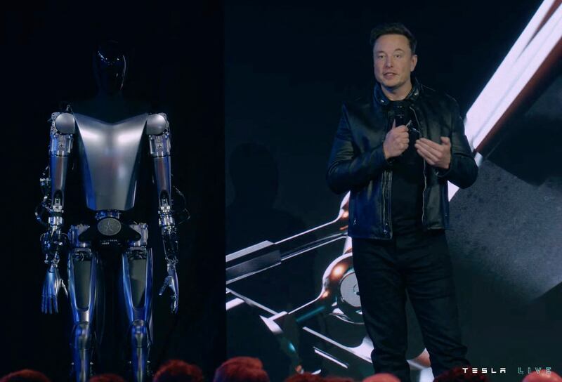 Mr Musk on stage next to Optimus the humanoid robot in Palo Alto, California, in September 2022 AFP