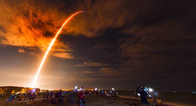 Crowds on the beach in Cape Canaveral, Fla., watch the launch of the SpaceX Falcon 9 Crew Dragon on its Crew-1 mission carrying four astronauts, Sunday, Nov. 15, 2020, in this 3 1/2-minute time exposure. The rocket was launched from Launch Complex 39A at Kennedy Space Center at 7:27 p.m. Sunday evening. (Malcolm Denemark/Florida Today via AP)