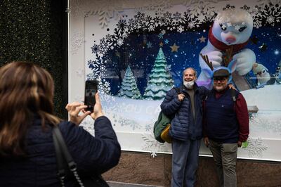 People take picture in front of Macy's Christmas window installation in New York on December 2. AFP