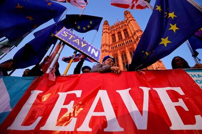 (FILES) In this file photo taken on October 22, 2019 Banners, Union and EU flags are displayed outside the Houses of Parliament in London on October 22, 2019, as MPs debate the second reading of the Government's European Union (Withdrawal Agreement) Bill.  The UK and European Union will on December 30 sign a mammoth trade pact to put the seal on their drawn-out Brexit divorce in the dwindling hours before they part ways definitively at the dawning of 2021. / AFP / Tolga Akmen / TO GO WITH STORY BY JITENDRA JOSHI
