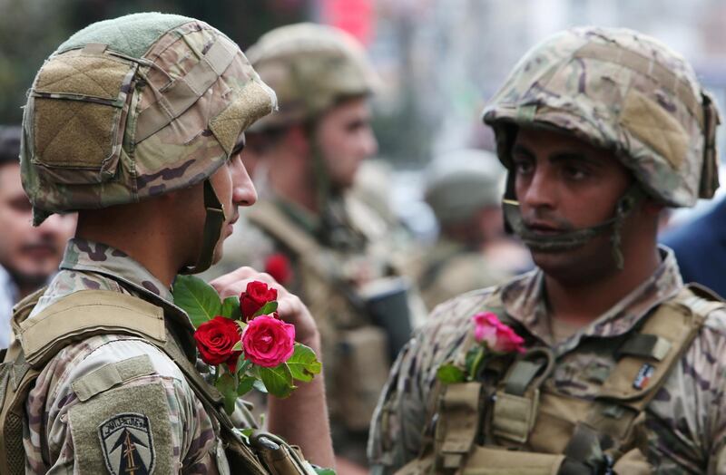 Soldiers wear roses given by demonstrators during an anti-government protest in Nabatiyeh. Reuters