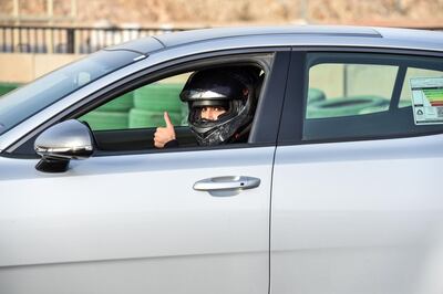 Rana Almimoni, a 30-year-old Saudi motor racing enthusiast, poses with the thumbs-up gesture in her car on the track in Dirab motor park, on the southern outskirts of the capital Riyadh, on July 19, 2018. - Speed-crazed women drivers are bound to turn heads in the deeply conservative desert kingdom, which overturned the world's only ban on female motorists in June as part of a much-hyped liberalisation drive led by Crown Prince Mohammed bin Salman. (Photo by FAYEZ NURELDINE / AFP)