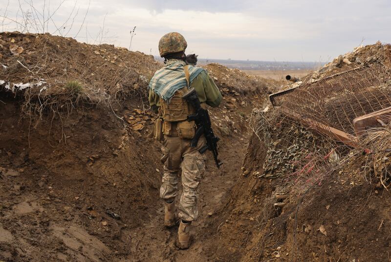 A Ukrainian soldier holds a cat on the line of separation from pro-Russian rebels near Debaltsevo, Ukraine, on December 3. AP