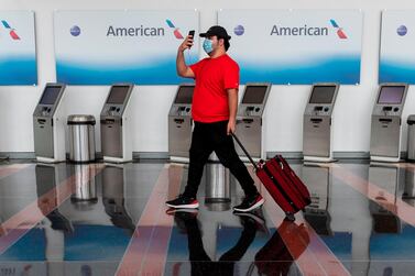 A passenger walks past empty American Airlines check-in terminals in the US. The International Air Transport Association (Iata) released an airline self-assessment health checklist to support operators through the pandemic. AFP.