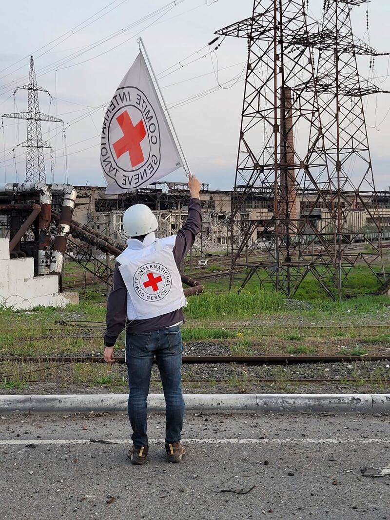 In this image provided by the International Committee of the Red Cross, an official waves a white flag while approaching the Azovstal steelworks in Mariupol, Ukraine. AP Photo