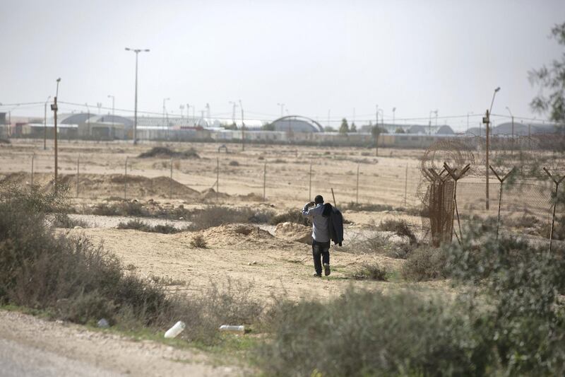 An African migrant is seen walking by the fence of the Holot open detention centre to the Saharonim Prison, following a protest in Israel's southern Negev desert near the Egyptian border on February 22, 2018. The migrants marched from the Holot open detention centre to the Saharonim Prison, chanting slogans and carrying signs demanding the prisoners' release, who are now on hunger strike to protest their arrest after.(Photo by Heidi Levine/Sipa Press).
