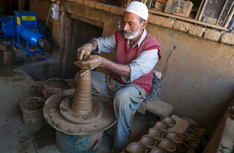 Abdul Salam Kumar, a Kashmiri Muslim potter, makes earthen lamps at his home on the outskirts of Srinagar. EPA