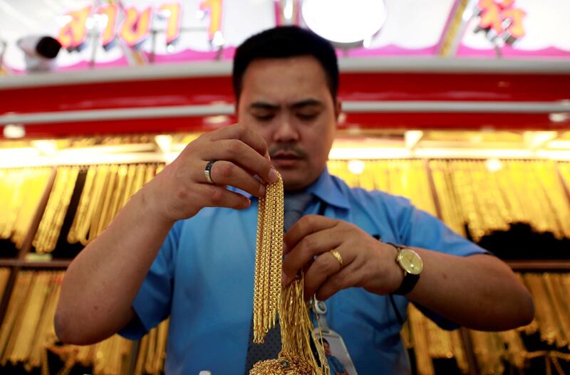 FILE PHOTO: A man holds necklaces in a gold shop in Chinatown in Bangkok, Thailand August 21, 2018. REUTERS/Soe Zeya Tun/File Photo
