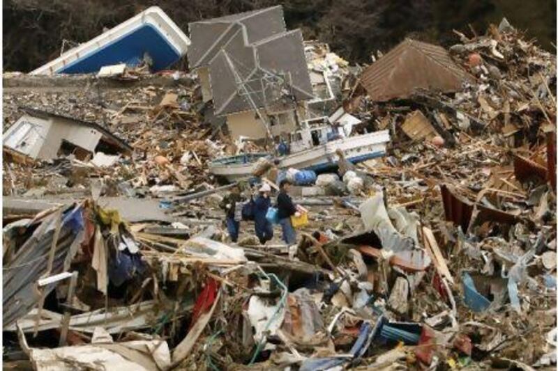 Villagers walk across a sea of debris yestedrday after they visited their home destroyed by a tsunami in Minamisanriku.